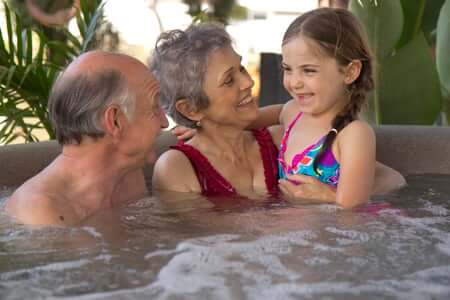 Grandparents with their grand daughter in a hot tub having fun