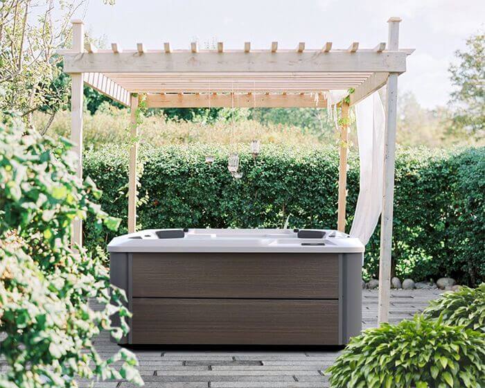 Hot Tub under white pergola in green backyard patio