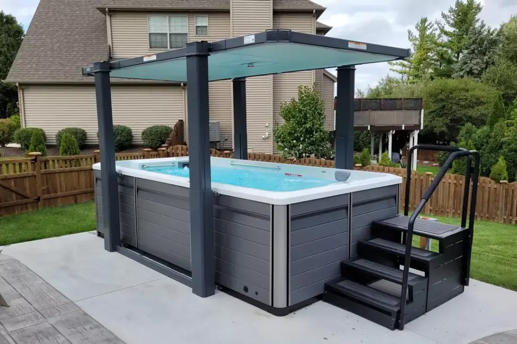 Swim Spa with cover and stairs on paved backyard patio