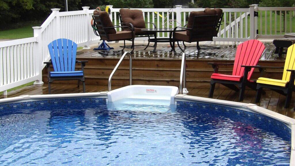 Colorful lawn chairs next to above ground pool in backyard