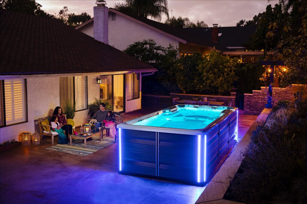 Swim spa glowing in a backyard at dusk